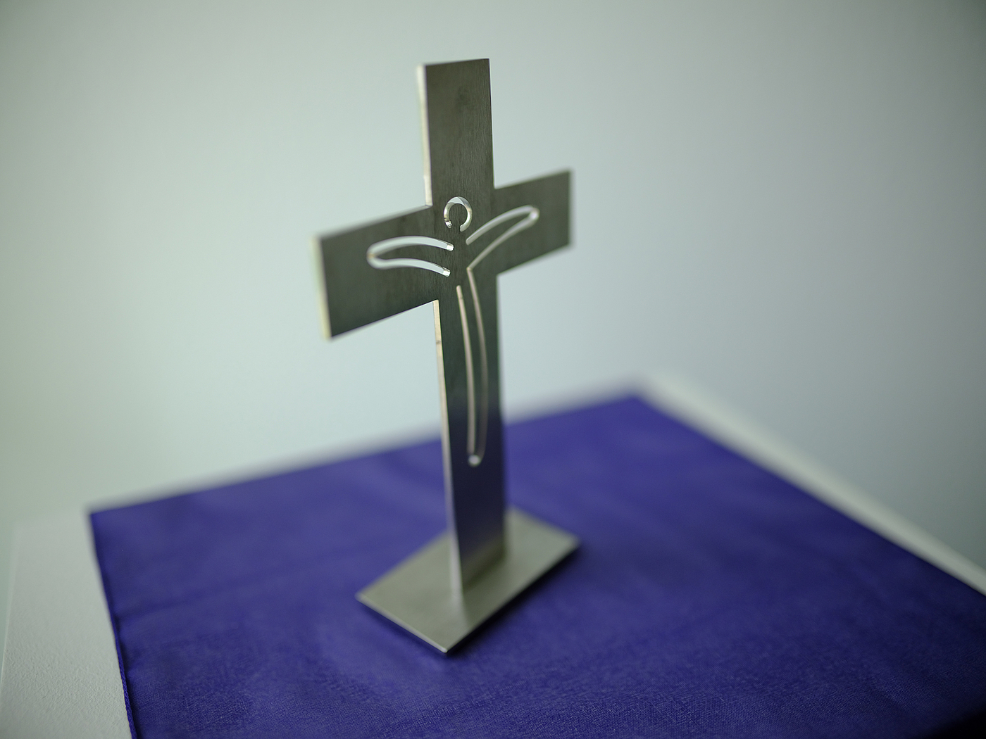 Silberne Kreuz-Skulptur auf einem Tisch