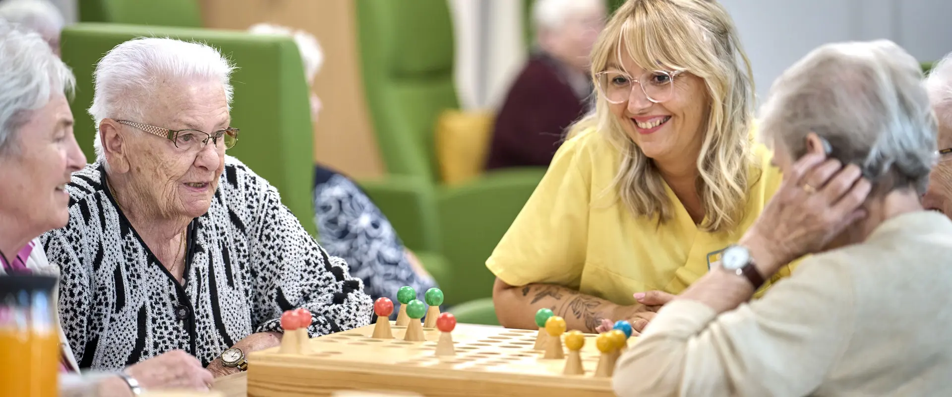 Gäste der Tagespflege spielen gemeinsam Mensch ärgere dich nicht.