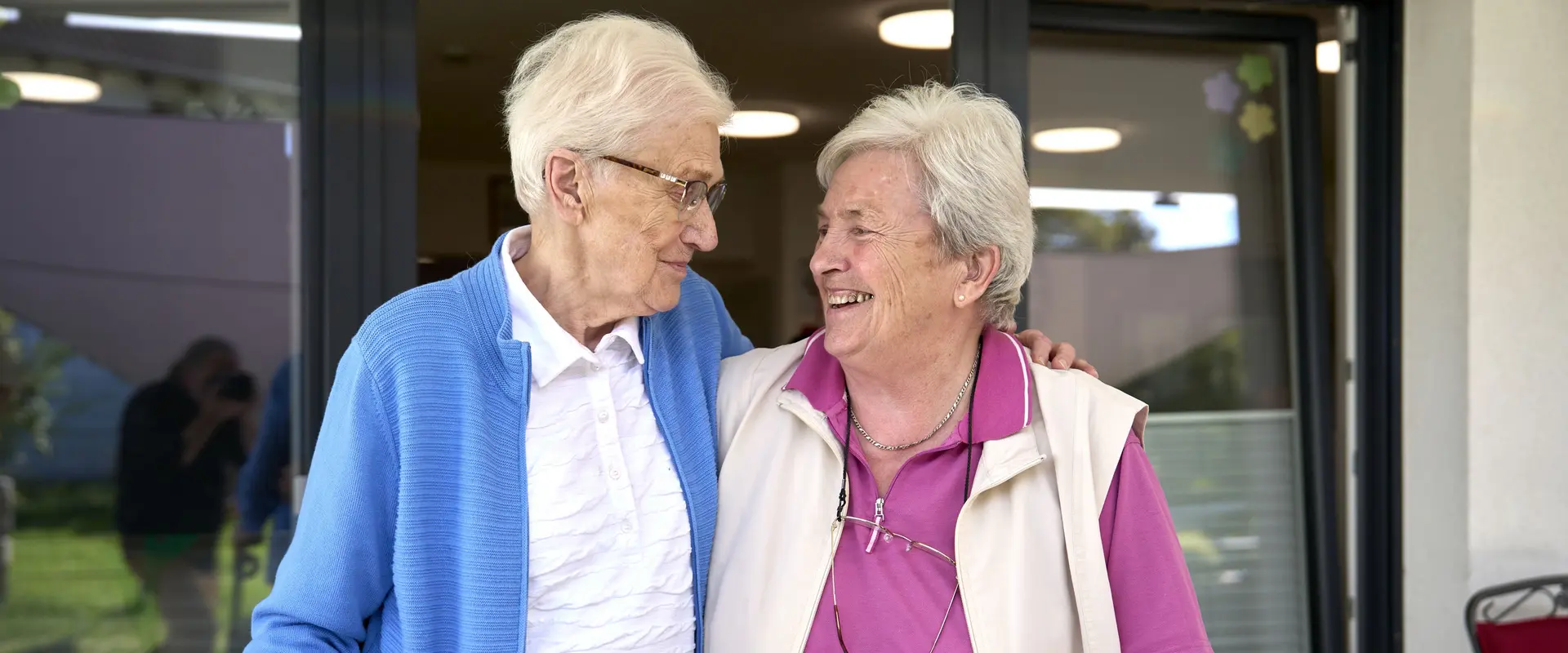 Das Bild zeigt zwei Seniorinnen, die miteinander lachen.