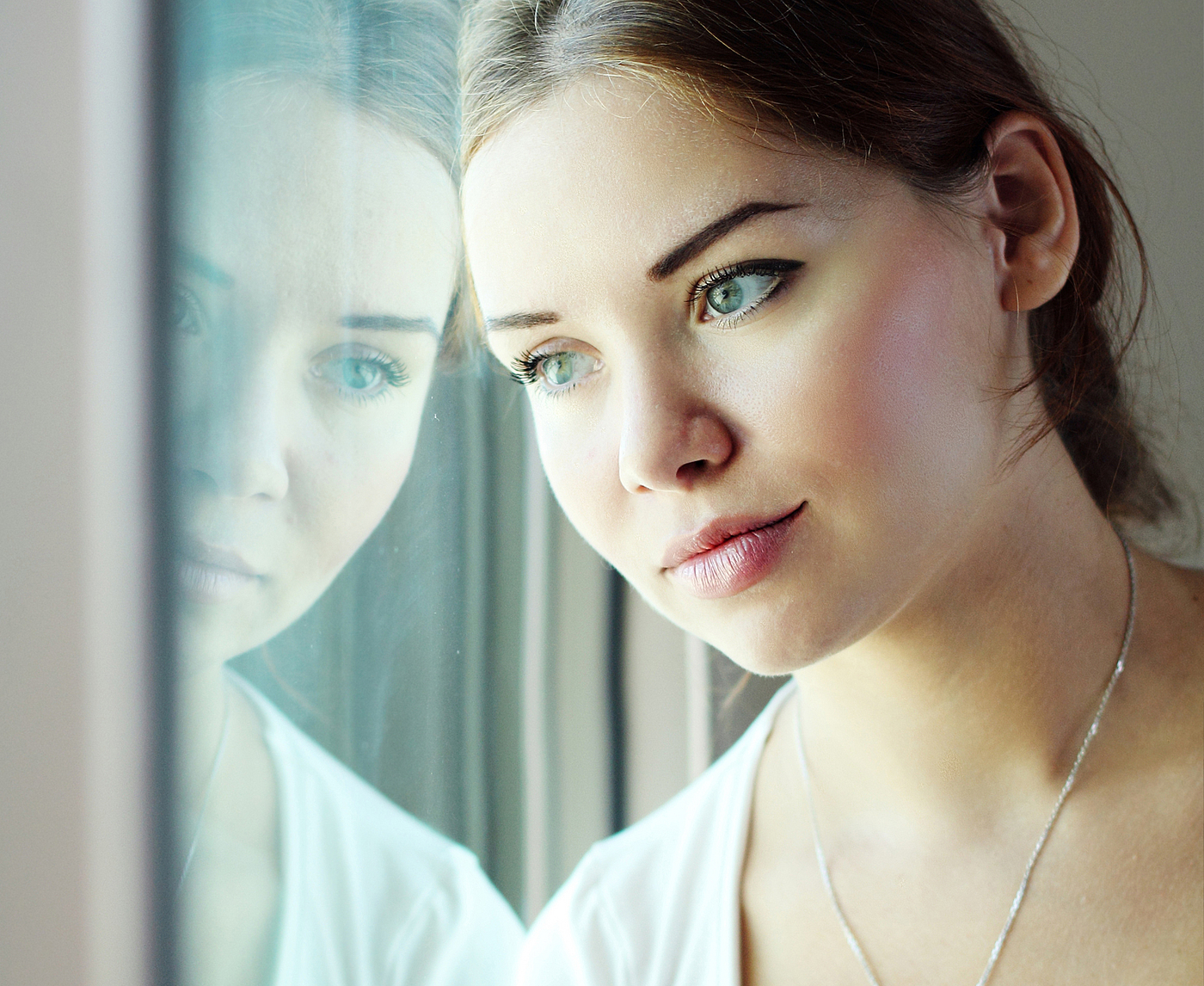 Frau blickt melancholisch aus dem Fenster