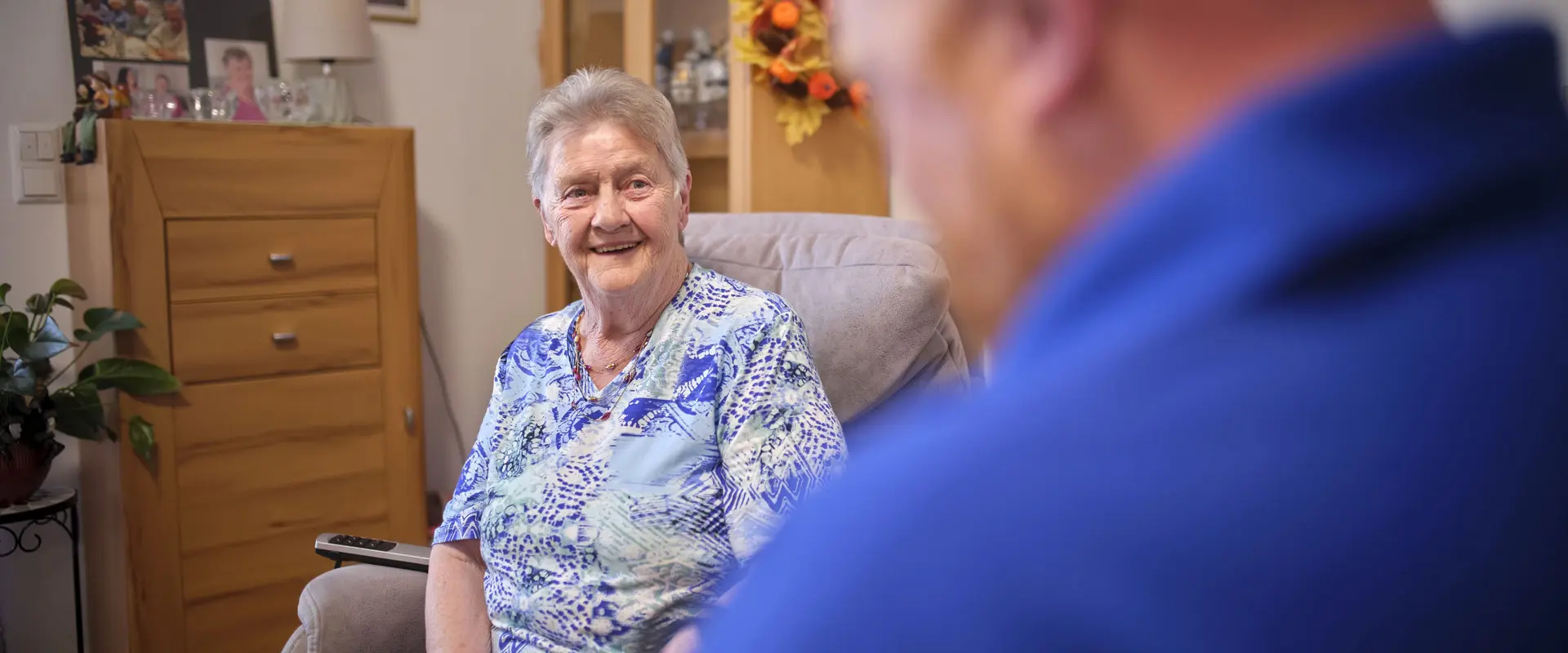 Eine Seniorin lacht einen Mitarbeitenden der DHH an.